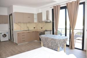 a kitchen with a table and a kitchen with a balcony at Lungomare private rooms in Vlorë