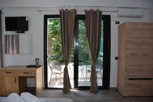 ヴロラにあるLungomare private roomsのベッドルーム1室(パティオに面したガラスのスライドドア付)