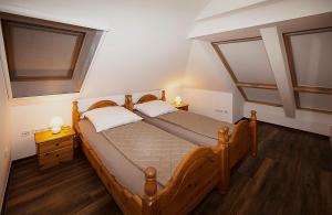 a bedroom with a wooden bed with two pillows at Haus Müritz, FeWo 15 Seeadler in Zielow