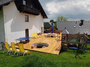 a deck with chairs and a fire pit in a yard at Ferienhaus Brenner in Sankt Kathrein am Offenegg