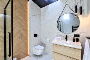 une salle de bain avec un lavabo et un miroir dans l'établissement Apartamenty Royal Maris 6 - najlepsza lokalizacja w Ustce, blisko plaży i portu, bezpłatny parking, ścicsłe centrum, à Ustka 60 autres photos