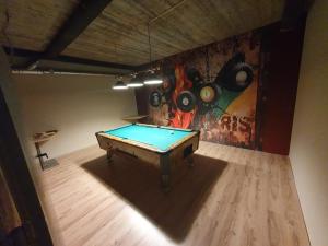 a room with a pool table in front of a painting at Ferienhaus Brenner in Sankt Kathrein am Offenegg