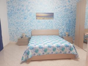 1 dormitorio con 1 cama con papel pintado de color azul en Sea House, en Pozzallo