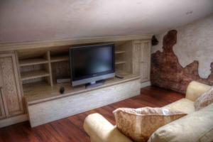 a living room with a flat screen tv on a entertainment center at Santa Maria ad Valetudinarium in Abbadia San Salvatore