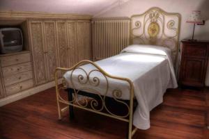 - une chambre avec un lit et une télévision dans l'établissement Santa Maria ad Valetudinarium, à Abbadia San Salvatore