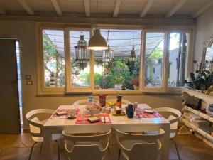 a table and chairs in a kitchen with windows at Il Cenacolo Di Sissi in Campagnano di Roma