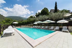a swimming pool with lawn chairs and umbrellas at Appartamento Alvavista1 in Trevi