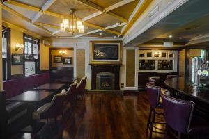 un ristorante con camino, tavolo e sedie di The Carraig Hotel a Carrick-on-Suir
