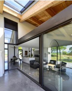 a living room with glass doors and a ceiling at Terre de Sienne in Charpey