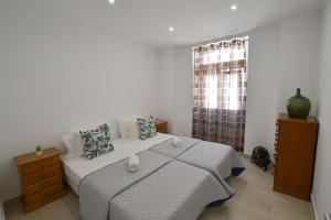 une chambre avec un grand lit et une fenêtre dans l'établissement Casa Dom Carlos, à Ferragudo