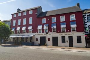 un edificio rosso sul lato di una strada di The Carraig Hotel a Carrick-on-Suir