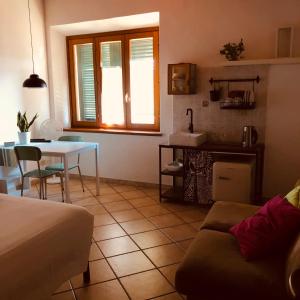 a living room with a table and a kitchen at Anitta GuestHouse in Castagneto Carducci