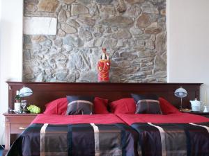 a bedroom with a red bed with a stone wall at Penzion U Císaře Zikmunda in Znojmo