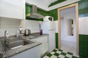 a kitchen with a sink and a refrigerator at Apartamentos Amalia By Mc in Benidorm