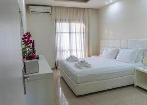 a bedroom with a white bed and a window at Macedon in Limenas +37 photos