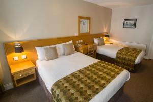 una camera d'albergo con due letti e un tavolo di The Carraig Hotel a Carrick-on-Suir Altre 37 foto