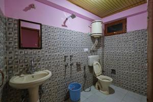 a bathroom with a sink and a toilet at Voyageur Nest in Manāli