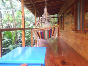 a hammock hanging from a porch of a house at El Tucan Jungle Lodge in Puerto Viejo