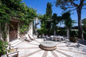 eine Terrasse mit einem Tisch, Stühlen und Bäumen in der Unterkunft VILLA DEL MARE - Numana, meravigliosa villa a 100mt dal mare in Numana