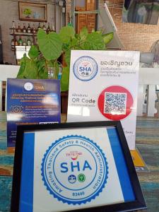 a tablet computer sitting on a table with a sign at Kata Leaf Resort Phuket - SHA Extra Plus in Kata Beach