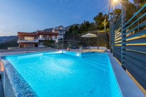 einen Pool in einer Villa mit einem Haus in der Unterkunft Bellevue in Podstrana