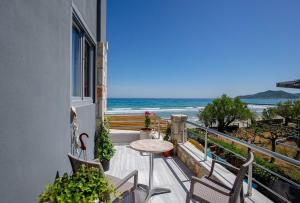 balcone con tavolo, sedie e vista sull'oceano di Golden Dolphin Studios & Apartments a Alykes