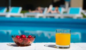 a glass of orange juice next to a bowl of fruit at Macedon in Limenas