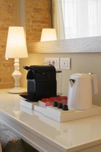 a coffee maker sitting on top of a counter next to a lamp at Boutique Hotel Carlo Felice in Cagliari