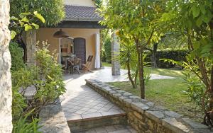 a garden with a stone pathway leading to a house at Villa Bouganville in Toscolano Maderno