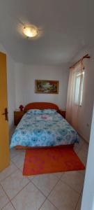 ein Schlafzimmer mit einem Bett, einem Fenster und einem Teppich in der Unterkunft Danijel in Sveti Juraj