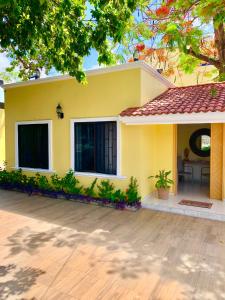 a yellow house with a patio in front of it at La Casa de los Alcatraces in Cancún