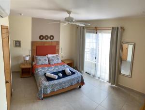a bedroom with a bed and a large window at La Casa de los Alcatraces in Cancún