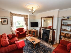 a living room with red furniture and a fireplace at Sheen Cottage in Whitby