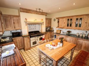 a kitchen with wooden cabinets and a wooden table at Sheen Cottage in Whitby
