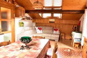 a living room with a table and a couch at Mansarda Caviola in Falcade