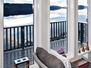 Una sala de estar con balcón con dos grandes ventanales. en 8 person holiday home in VATNE, en Vatne