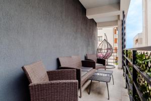 a balcony with wicker chairs and a table at SUMMER QUANTUM VALENTINE'S APARTMENT in Năvodari