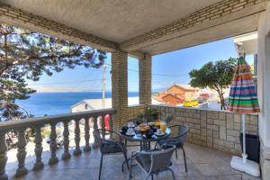 a table on a balcony with a view of the ocean at Apartments Matia in Senj