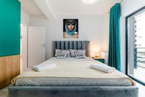 a bedroom with a large bed with blue curtains at SUMMER QUANTUM VALENTINE'S APARTMENT in Năvodari