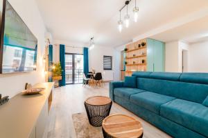 a living room with a blue couch and a table at SUMMER QUANTUM VALENTINE'S APARTMENT in Năvodari