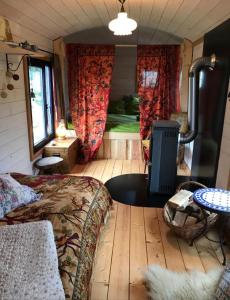 ein Schlafzimmer mit einem Bett und einem Kamin in einem Zimmer in der Unterkunft Der Zirkuswagen und das Elfenhaus in Dittmannsdorf