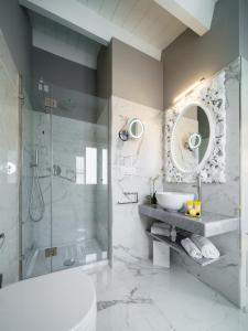 a bathroom with a shower and a sink and a mirror at Boutique Hotel Carlo Felice in Cagliari
