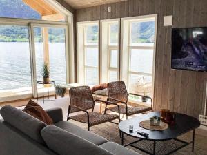 a living room with a couch and chairs and windows at Holiday home skei i jølster V in Skei