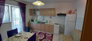 eine kleine Küche mit einem weißen Kühlschrank sowie einem Tisch und Stühlen in der Unterkunft Danijel in Sveti Juraj + 16 Fotos