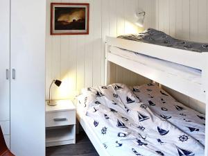 a bedroom with a bunk bed with blue and white sheets at 8 person holiday home in VATNE in Vatne
