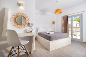 a bedroom with a bed and a desk and a mirror at Kasteli Luxury Rooms in Perissa