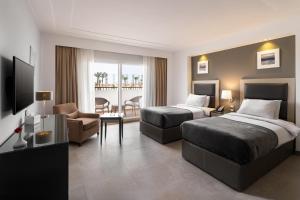Ein Bett oder Betten in einem Zimmer der Unterkunft Rhactus Hotel, New Alamein