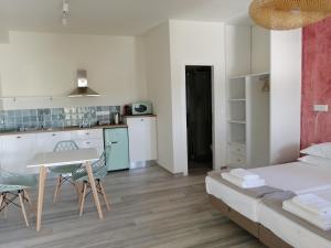 a kitchen and a living room with a bed and a table at Villa Nena - Studio Suites in Kalami