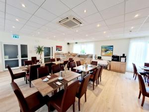 - un restaurant avec des tables et des chaises dans une salle dans l'établissement Parkhotel Lippstadt, à Lippstadt