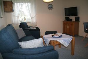 ein Wohnzimmer mit einem Sofa und einem Tisch in der Unterkunft Ferienhof Carstensen, Wohnung Leuchtturm in Süderende